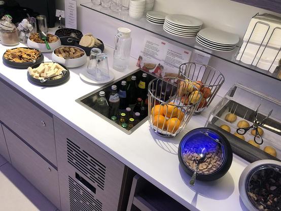 Free stuff for first class bourgeoisie: snacks, (non alcoholic) drinks, some fruit, butter madeleines and nutty stuff. Obviously, coffee is served as well.