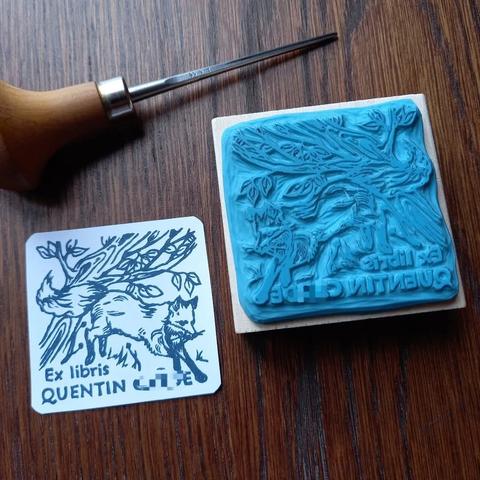 Tampon gravé à la main. Ex-libris ayant pour sujet un renard courant dans la forêt.