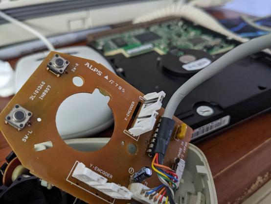 Inside of PC-98 mouse, which is using weird leaf spring pin-like metal contacts instead of optical sensors. ALPS logo on board.