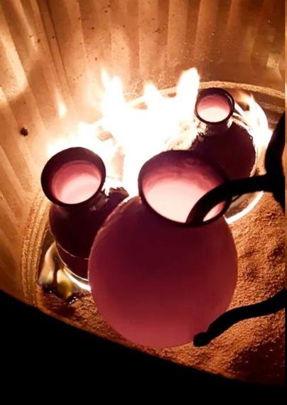 Placing a pot in the reduction bin during the raku process.