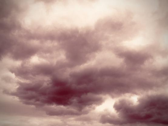 Cumulonimbus clouds stretch across the sky, hued in red.
