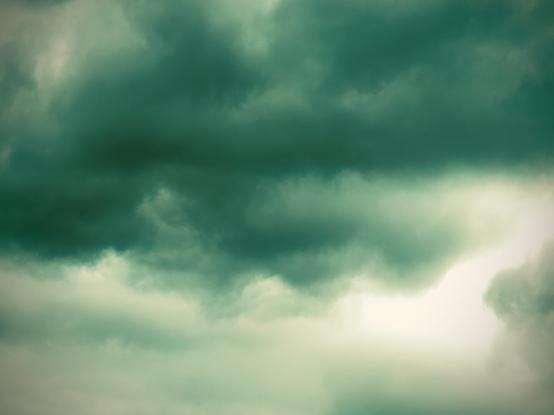 Cumulonimbus clouds stretch across the sky, hued in green.