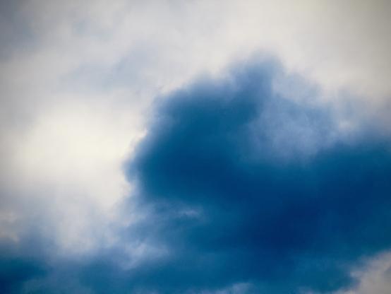 Cumulonimbus clouds stretch across the sky, hued in blue.