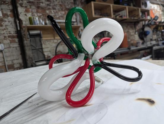 White, Green, Red and black doodle with colors descending in size. Tools an brick wall background.