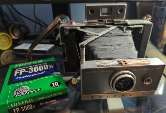 A Polaroid Land Camera 100 and an expired pack of the discontinued Fujifilm FP-3000b instant film. It's hard to come by these days, but it remains one of the most missed instant films out there.