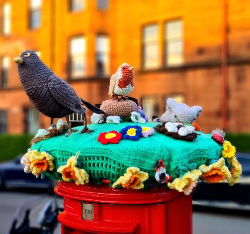 A knitted spring themed post box topper.