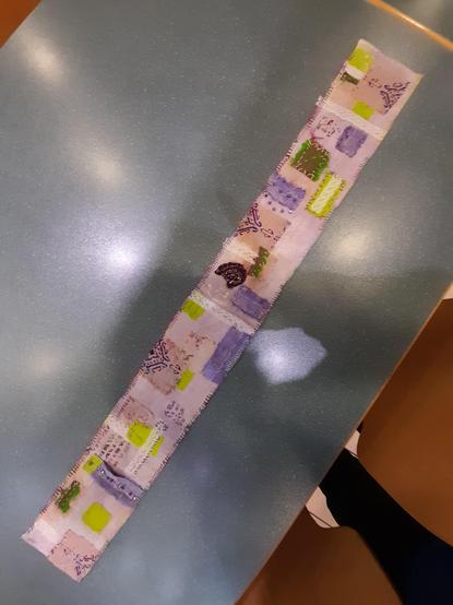 The whole fabric stripe finished. The white coton flanell was coloured with red fruit tea. I used mainly purple and bright acid green colourshades for the collage, lavender glass rocailles with a special lustering, and multicoloured/variegated threads.
