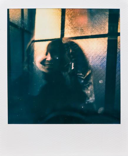 double exposure polaroid of the silhouette of a woman with her smiling face showing through part of the image.