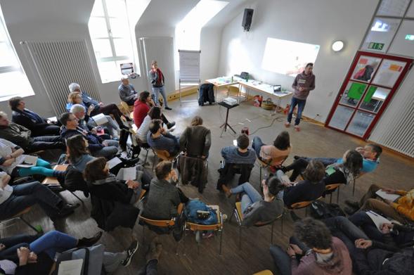 Plenum mit Menschen in einem Stuhlkreis (Symbolbild)