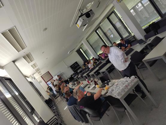 Room view of one of the hacking rooms. People discussing and working on laptops.