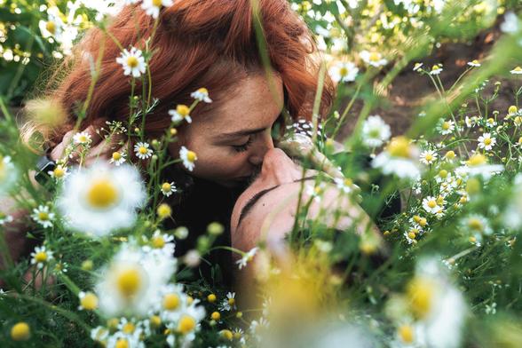 couple kissing in a field of daisies