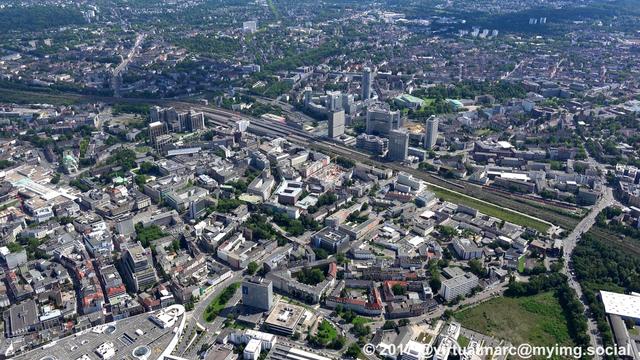 An aerial photo of the Essen Central station with the Postbank and Evonik Buildings,
The big round tower is the central of innogy (former RWE tower).
Right of it you can see the Aalto Theater and the Philharmonic of Essen.