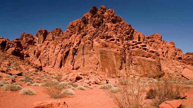 A wide angle view of the Valley of Fire State Park red rock formations from shifting sandstone. The mountainous landscape reflects skulls and fire.