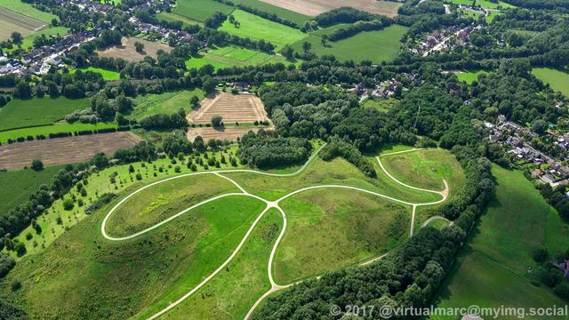 An aerial photo of the spoil heap near the Honermann settlement at the former General Blumenthal 8 mine in Oer-Erkenschwick, sourrounded by trees. There are some houses and a railway track around.