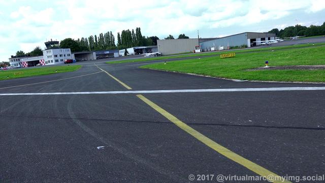 A photo from the runway at the Marl Lohemühle airport while landing the gyrocopter. Some hangers with sport planes can be seen at the top right. The tower can be seen at the top left.