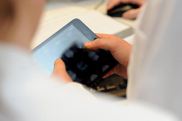 Das Bild zeigt einen Arzt, der ein Tablet in den Händen hält. © Charité | Wiebke Peitz