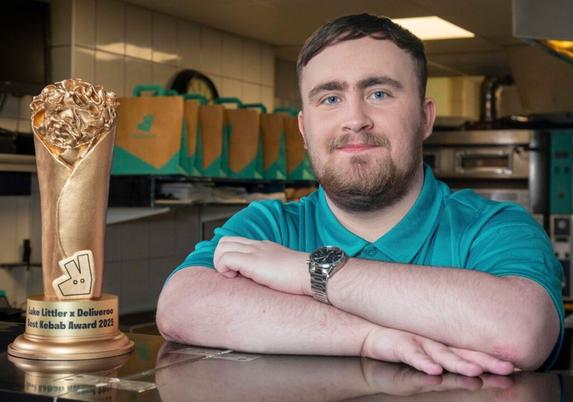 Luke Littler with the trophy - Deliveroo