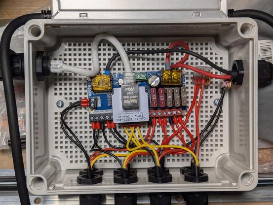 The inside of the box, with a circuit board connecting all the wires. The wires are relatively tidy. The circuit board is the LED driver board.