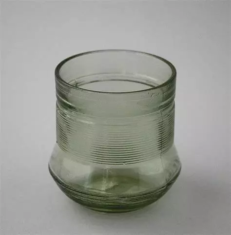 a greenish drinking glass with horizontal stripes