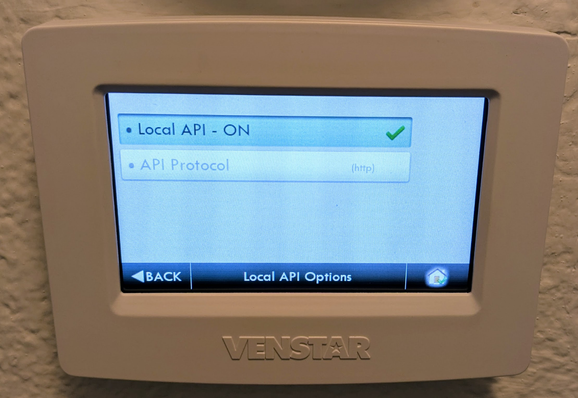 A Venstar thermostat displaying its "Local API Options" settings screen with "Local API - ON" activated and using HTTP protocol.

(Description assisted by Claude AI.)