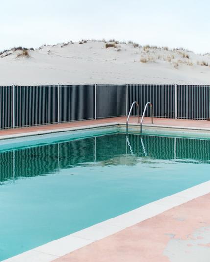 Piscine déserte entourée par les dunes de sables