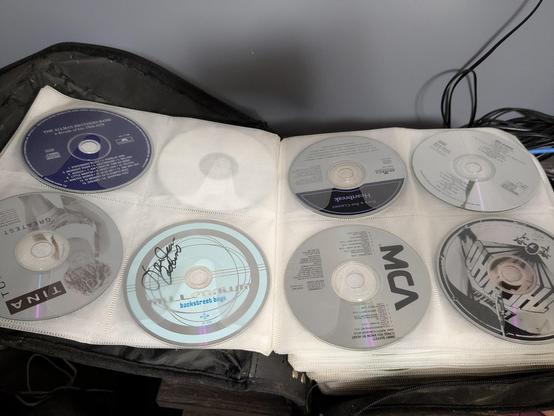 A photo of a book filled to the brim with music CDs.