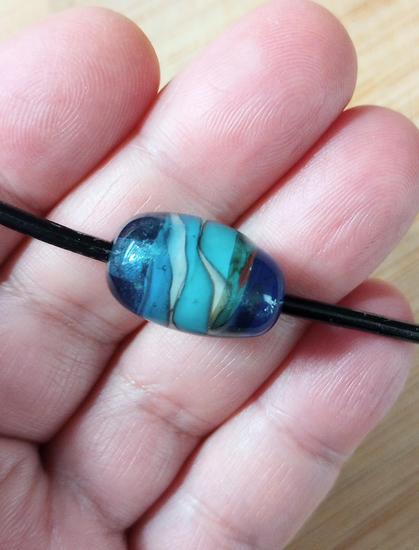 Large lampwork glass bead in shades of blue.