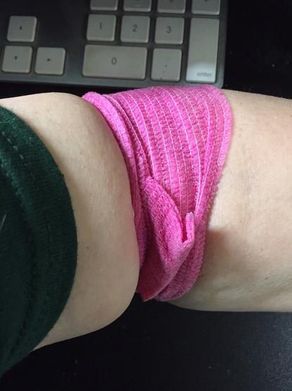 Close up of the bright pink pressure bandage on the crook of my (so pale it's sallow) elbow, after donating blood.