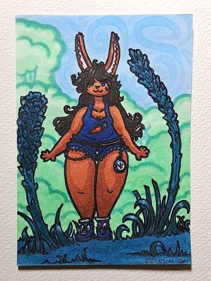 Un dessin représentant une femme-lapin à la fourrure marron claire, portant un marcel bleu avec une carotte dessinée dessus, un jean très court avec des chaînes et une montre, des baskets bleus aux lacets blancs, à la chevelure brune généreuse et ondulée, se tenant debout et souriante autour de plantes aux couleurs vertes et turquoises ; en fond des arbres verts pâles.