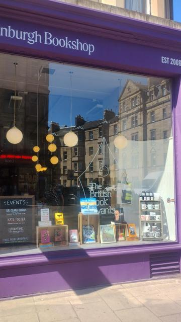 Outside view of the completed British Book Awards window of the Edinburgh Bookshop, with winning books and the giant pen nib logo painted on the glass