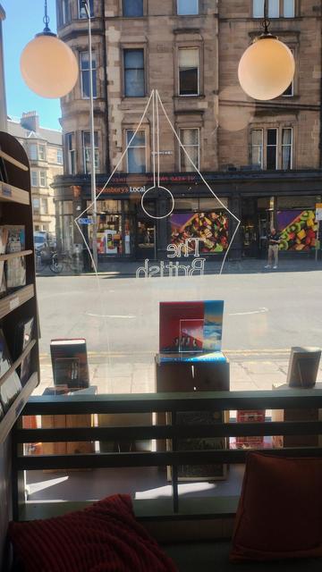 Inside view of the finished British Book Awards window with winning books, and the pen nib logo painted on the glass