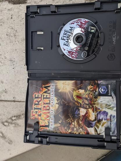 Photograph of an open for the Nintendo GameCube game Fire Emblem Path of Radiance. The manual is on one side. The disc on the other