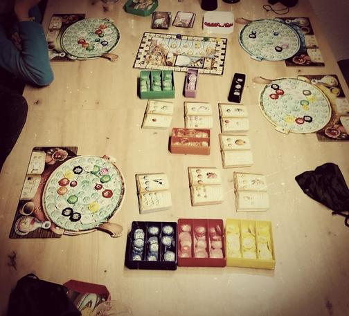 Gesamtsicht von oben auf den Spieltisch, wo das Spiel Quacksalber von Quedlinburg aufgebaut ist.