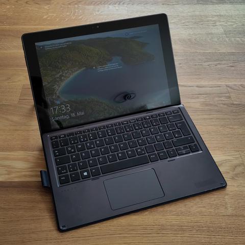Foto des genannten Tablets mit angedockter Tastatur. Der Bildschirm zeigt den typischen Windows 10-Lockscreen.