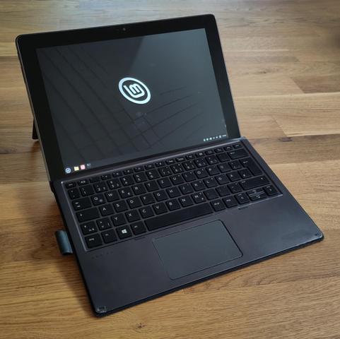 Foto des genannten Tablets mit angedockter Tastatur. Der Bildschirm zeigt den typischen Linux Mint-Desktop.