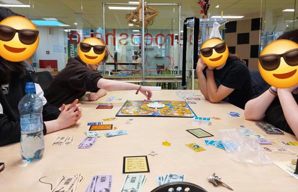 Four people (and me )seated at a table playing the game of life. If you were to Zoom in coma you would be able to see that the majority of cars are occupied by gay couples or furries