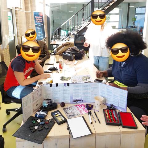 Four students playing DnD, from the perspective of the DM. 

Almost all are seated except for the kid with ADHD