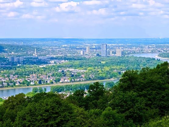 Another view from a mountain. Forest in the foreground, then the Rhine in the valley, which runs in an arc through the countryside. The city of Bonn can be seen on the opposite bank.