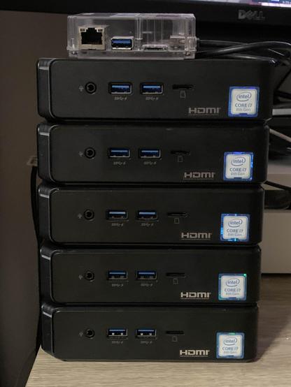 A stack of five Asus Chromebox 3 devices, with Servo debug box put on top of them.