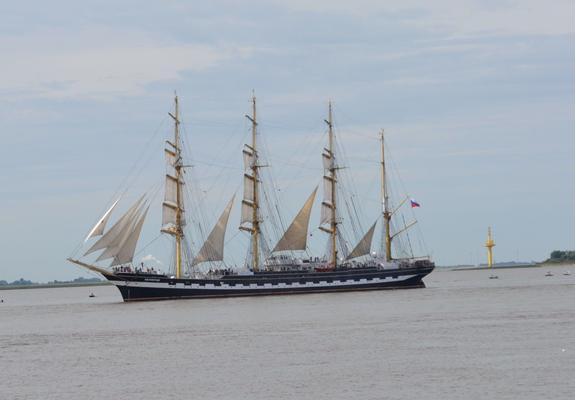 Segelschiff mit vier Masten - Viermastbark - mit schwarz-weißem Rumpf und teilweise gesetzten Segeln.