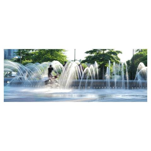 Portrait of a cyclist crossing streams of water, blurred due to slow shutter speed