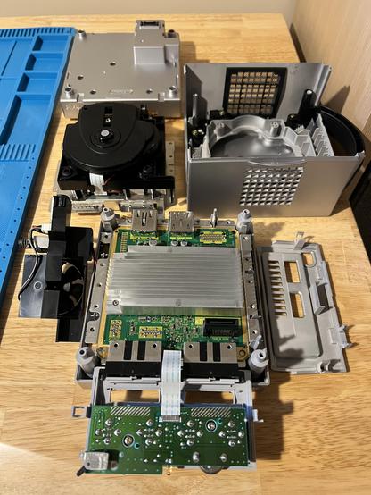 Platinum GameCube and Game Boy Player completely disassembled on a desk.