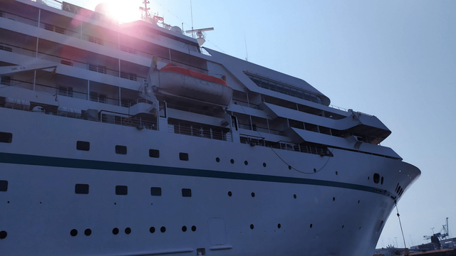 Tiefstehende Sonne über einem großen Passagierschiff