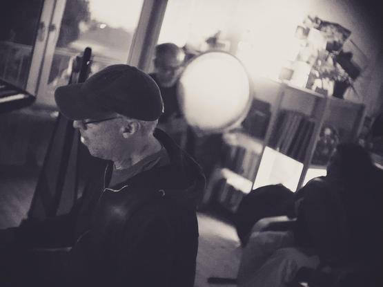 Three people in a studio playing various instruments.