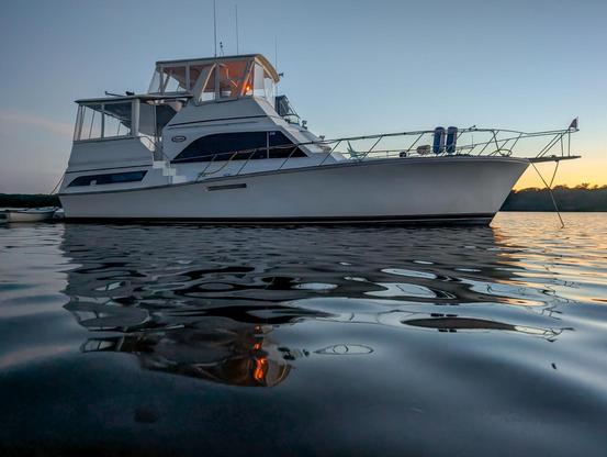 1984 Ocean 46' yacht at anchor at twilight reflect in water with some light wind ripples