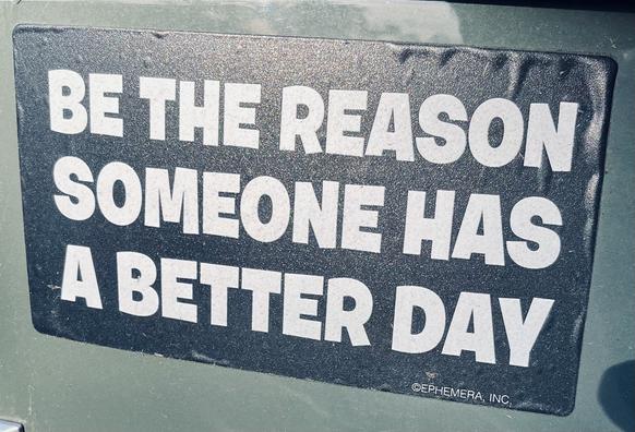 Bumper sticker that reads “be the reason someone has a better day.”