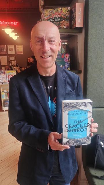 Author Chris Brookmyre holding his new novel in the Edinburgh Bookshop