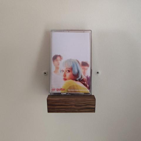 Cassette of Air Guitar by Sobs resting on a wall mount.