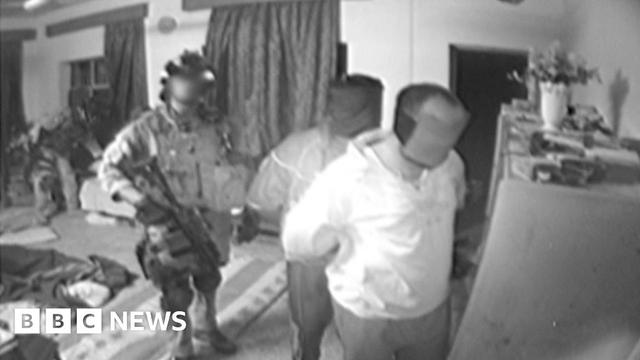 Image from a 2006 SAS squadron compilation video from Iraq showing a member of the squadron with two other men, who appear to be handcuffed