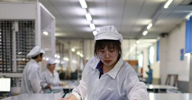 DONGYING, CHINA - MARCH 11: Employees work on the production line of solar panels at an intelligent workshop on March 11, 2025 in Guangrao County, Dongying City, Shandong Province of China.